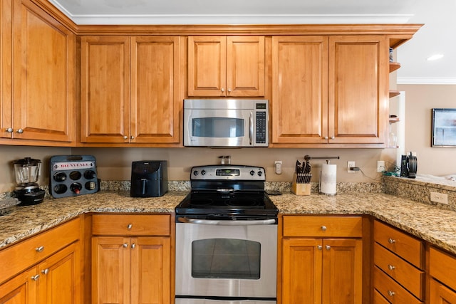 kitchen featuring appliances with stainless steel finishes, crown molding, and light stone counters