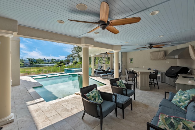 view of pool with exterior bar, an outdoor living space, a patio area, area for grilling, and ceiling fan