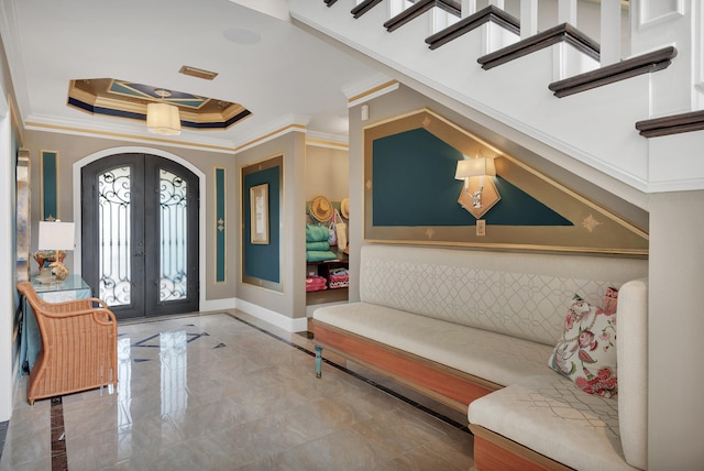 foyer entrance featuring french doors, crown molding, a tray ceiling, and light tile flooring