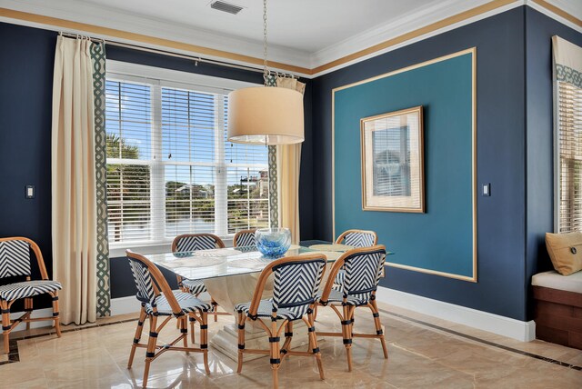 dining area featuring ornamental molding and light tile floors