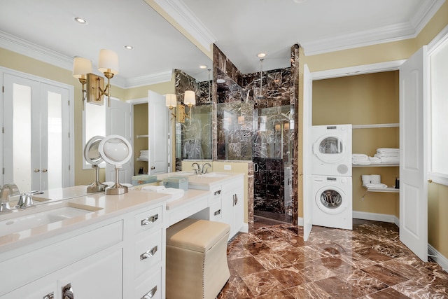 bathroom with tile flooring, stacked washer and clothes dryer, double sink vanity, a shower with shower door, and ornamental molding