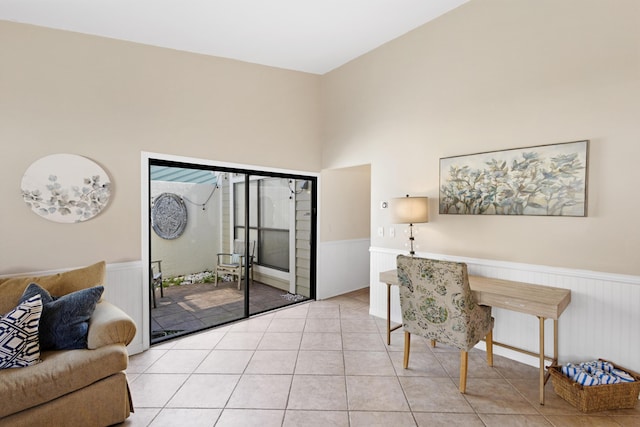 office with a wainscoted wall, light tile patterned floors, and a towering ceiling