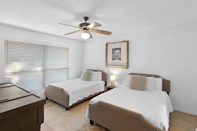 tiled bedroom featuring ceiling fan and a textured ceiling