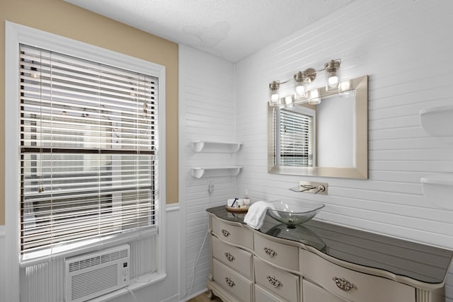 bathroom featuring a textured ceiling, vanity, and cooling unit