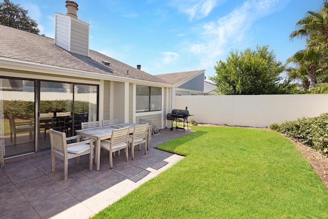 view of yard featuring outdoor dining space, a patio area, and fence