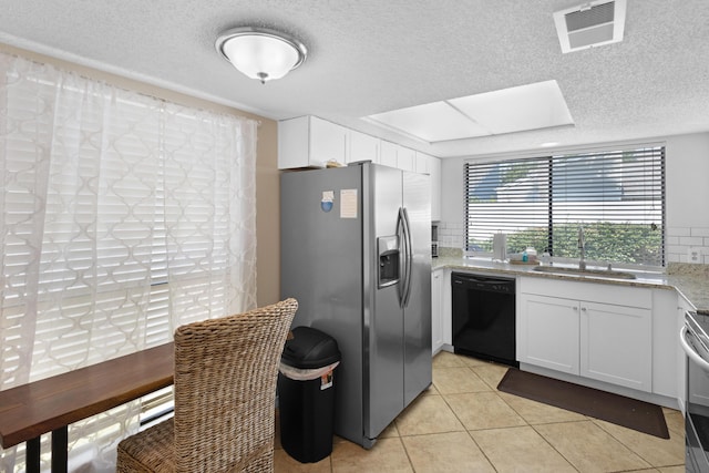 kitchen with light stone counters, stainless steel appliances, a sink, visible vents, and white cabinetry