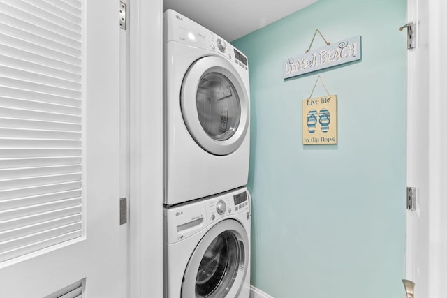 clothes washing area featuring stacked washer / drying machine