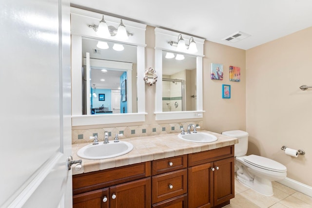 bathroom with decorative backsplash, vanity, an enclosed shower, toilet, and tile patterned floors