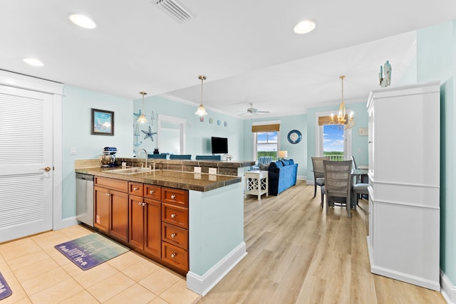 kitchen with ceiling fan with notable chandelier, pendant lighting, sink, stainless steel dishwasher, and kitchen peninsula