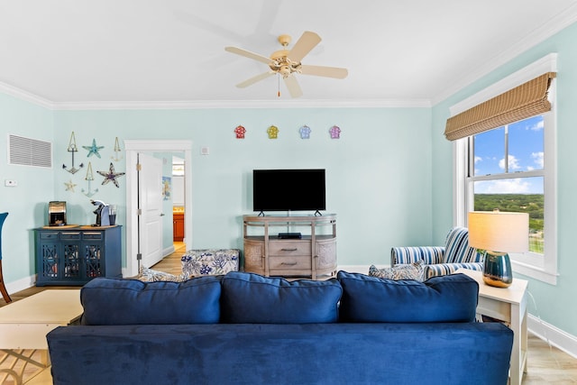 living room featuring ceiling fan, ornamental molding, and light wood-type flooring