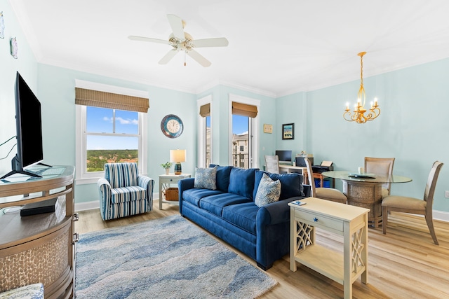 living room with ornamental molding, ceiling fan with notable chandelier, and light hardwood / wood-style flooring