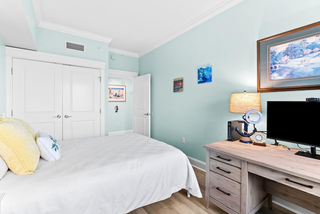 bedroom featuring ornamental molding, a closet, and light wood-type flooring