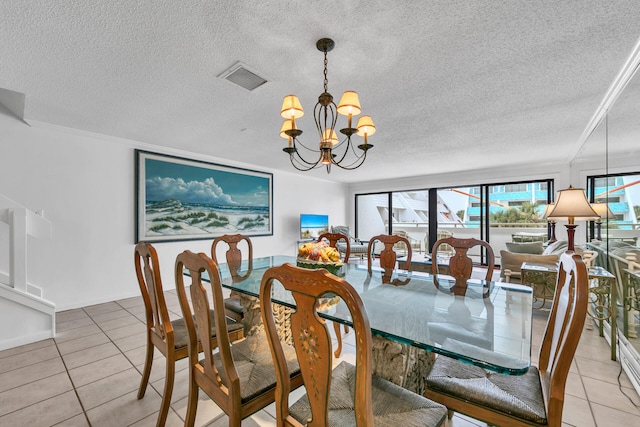 tiled dining area with a textured ceiling and a chandelier