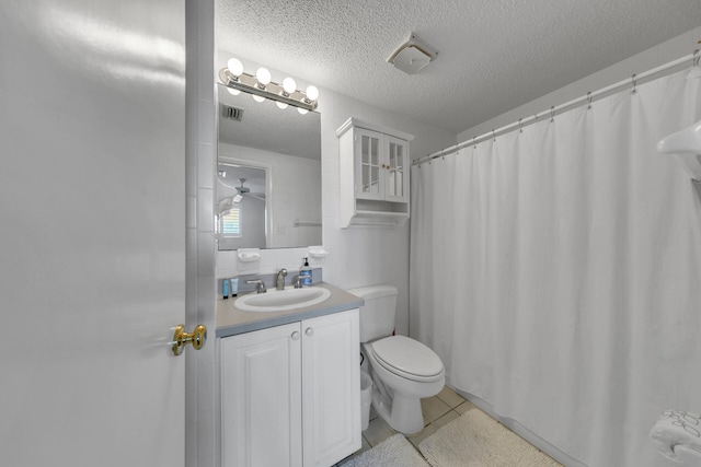 bathroom featuring vanity, tile patterned floors, a textured ceiling, and toilet