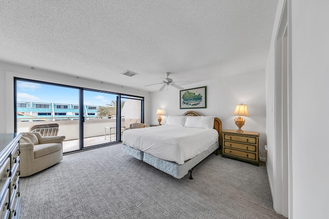 bedroom with ceiling fan, access to outside, light colored carpet, and a textured ceiling