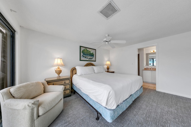 carpeted bedroom featuring connected bathroom, a textured ceiling, and ceiling fan