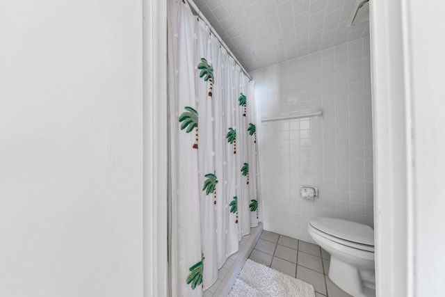 bathroom with toilet, tile walls, tile patterned floors, and a shower with shower curtain