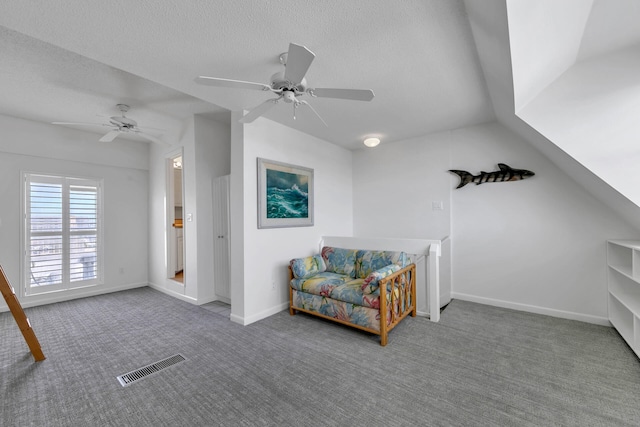 sitting room featuring vaulted ceiling, carpet, ceiling fan, and a textured ceiling