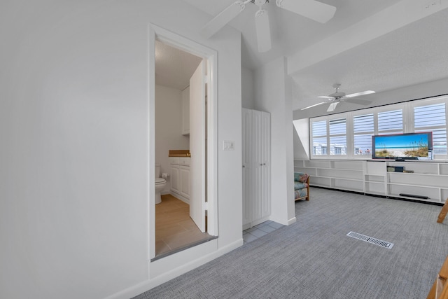 interior space featuring light carpet and ceiling fan