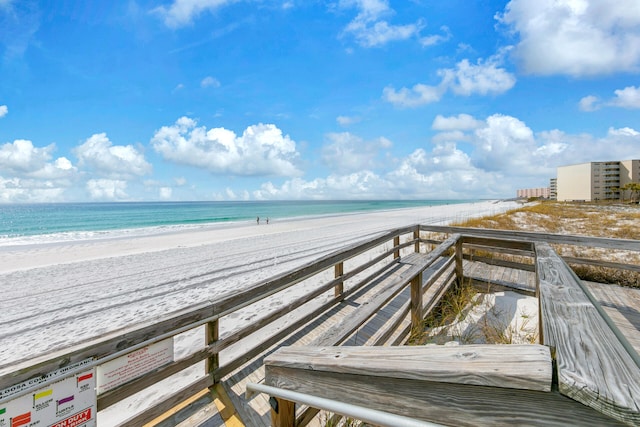 view of community featuring a water view and a beach view