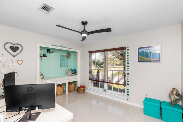 office space featuring a textured ceiling, ceiling fan, and light tile patterned flooring