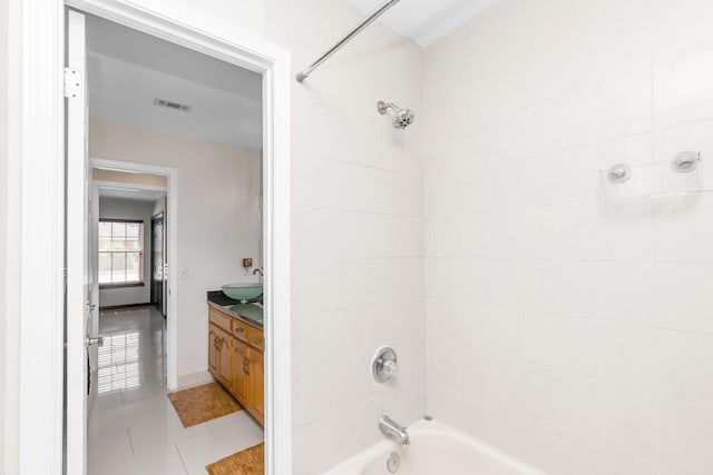 bathroom featuring vanity, tile patterned flooring, and tiled shower / bath combo