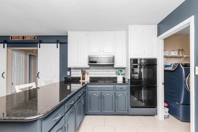 kitchen featuring black appliances, white cabinets, dark stone counters, and a barn door