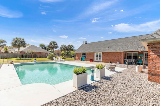 view of swimming pool with french doors and a patio area