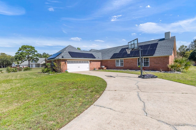 view of front of home with a front yard, a garage, and solar panels