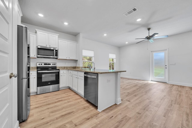 kitchen featuring kitchen peninsula, ceiling fan, stainless steel appliances, light hardwood / wood-style floors, and white cabinetry