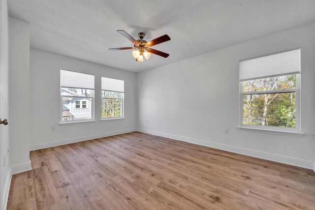 spare room featuring ceiling fan, a textured ceiling, and light wood-type flooring