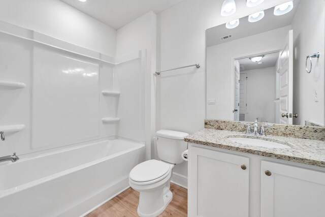 full bathroom with shower / washtub combination, wood-type flooring, toilet, and large vanity