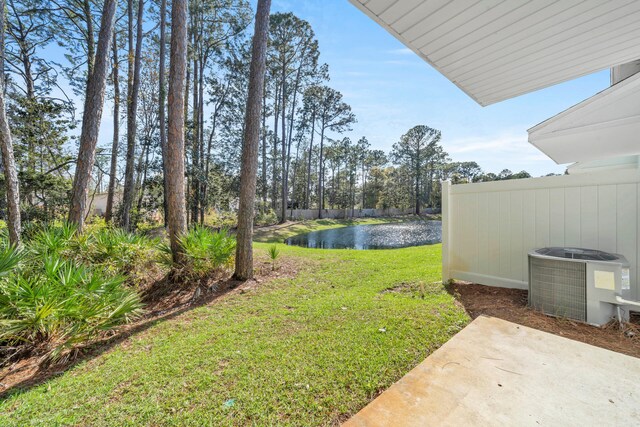 view of yard with a water view, central air condition unit, and a patio