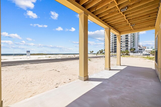 view of patio / terrace featuring a water view and a view of the beach