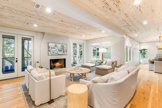 living room featuring french doors, a premium fireplace, and light wood-type flooring