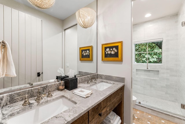 bathroom with walk in shower, oversized vanity, toilet, and dual sinks