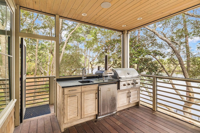 wooden deck with area for grilling, exterior kitchen, and sink