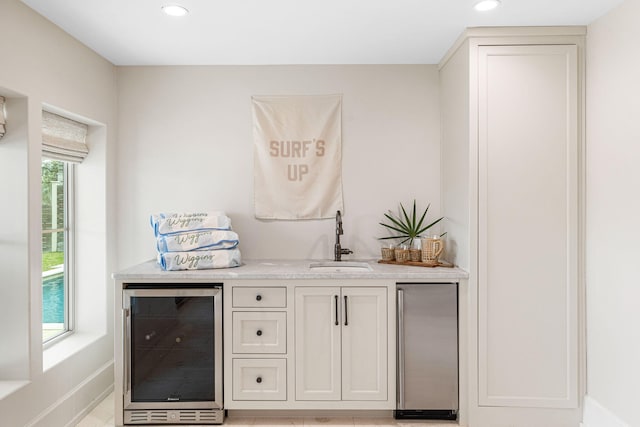 bar with sink, refrigerator, and beverage cooler