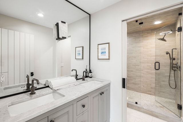 bathroom featuring a shower with door, tile flooring, and double sink vanity