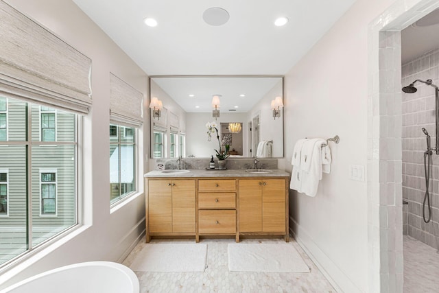 bathroom with tiled shower, dual vanity, and tile flooring