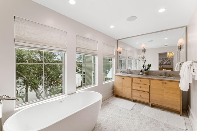 bathroom with a wealth of natural light, tile floors, a bathing tub, and double sink vanity