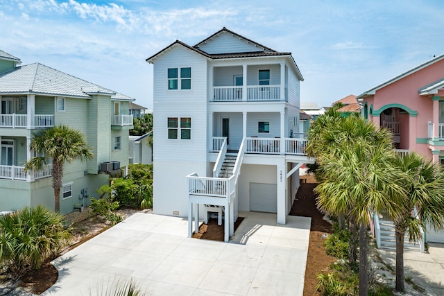 beach home with a balcony, a garage, and central air condition unit