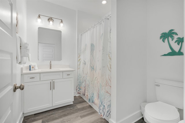 bathroom with hardwood / wood-style flooring, toilet, and vanity