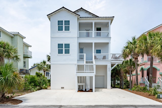 raised beach house featuring a balcony and a garage