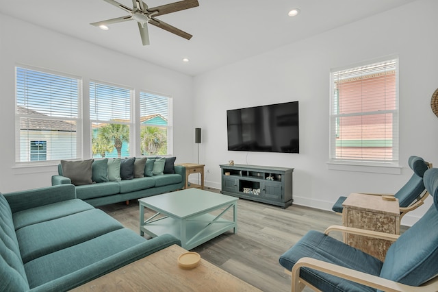 living room featuring light hardwood / wood-style flooring, ceiling fan, and a wealth of natural light