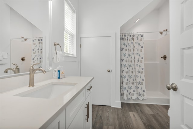 bathroom with walk in shower, hardwood / wood-style floors, and vanity