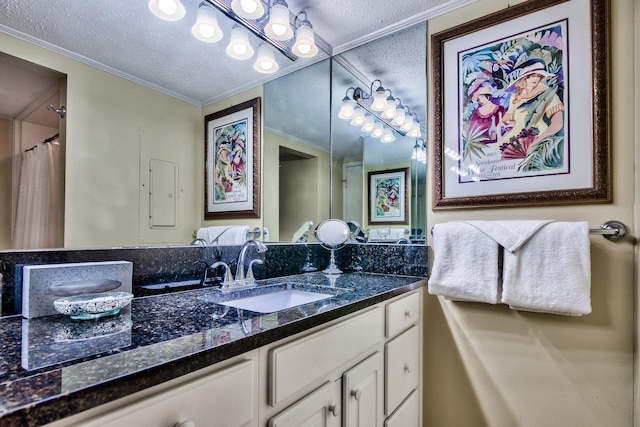 bathroom featuring a textured ceiling, vanity, and ornamental molding