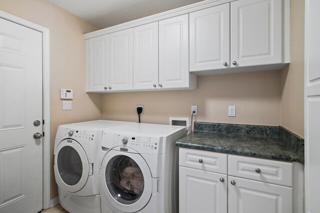 clothes washing area with cabinets and washing machine and dryer