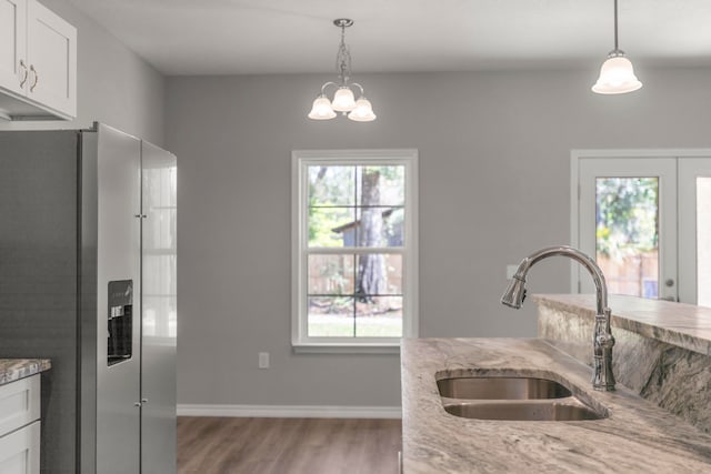 kitchen with plenty of natural light, sink, stainless steel fridge with ice dispenser, and white cabinetry