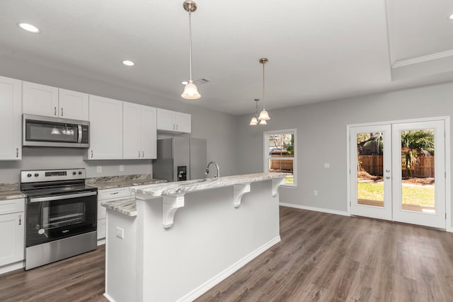 kitchen with a center island with sink, dark wood-type flooring, stainless steel appliances, and white cabinets